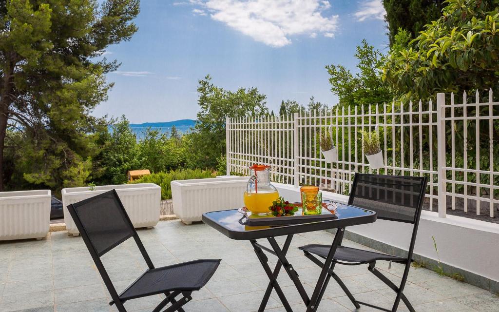 a patio table with two chairs and a pitcher of juice at "NM" Luxury apartments in Split