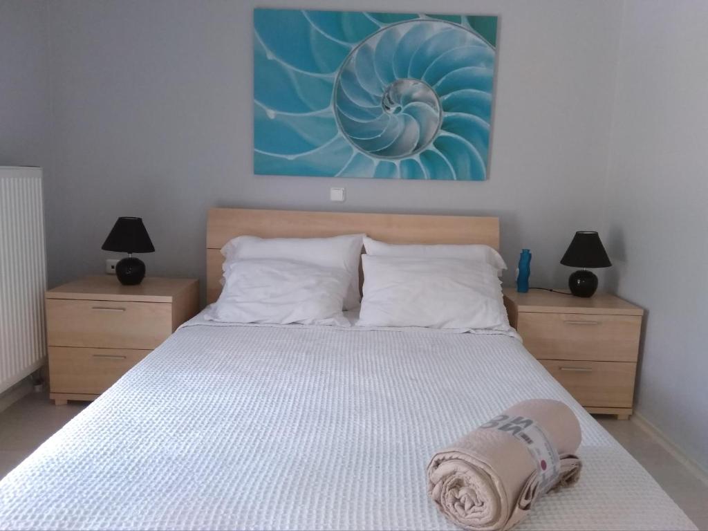 a bedroom with a bed with a blue painting on the wall at Christina's House in Iraklitsa