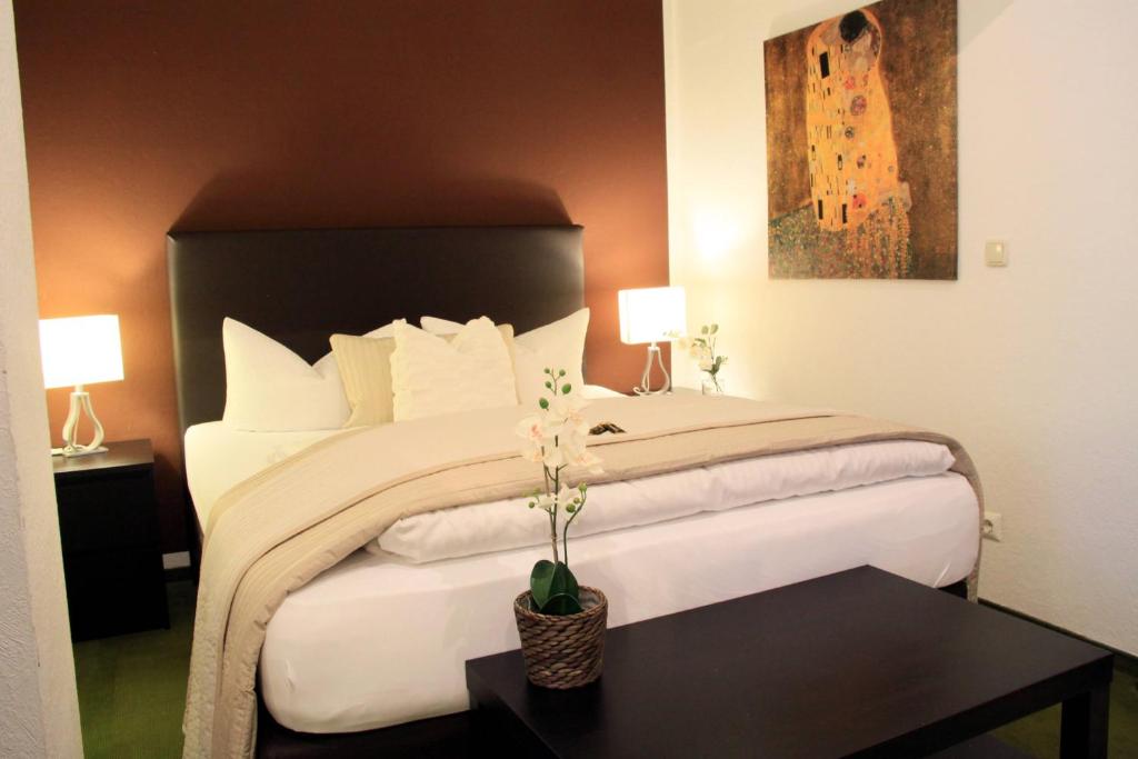 una camera da letto con un grande letto bianco e un tavolo nero di Hotel "Am Fischhof" a Weißensee
