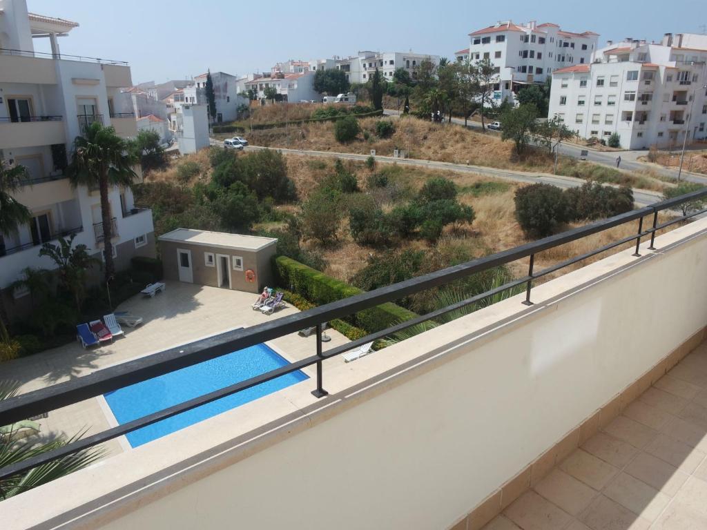 een balkon met uitzicht op een zwembad bij C04 - Pool View 3 Bed Apartment in Lagos