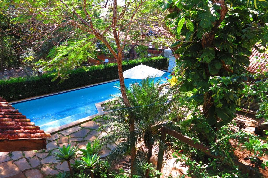 una piscina en un patio con un árbol en Sossego Homestay en Chapada dos Guimarães