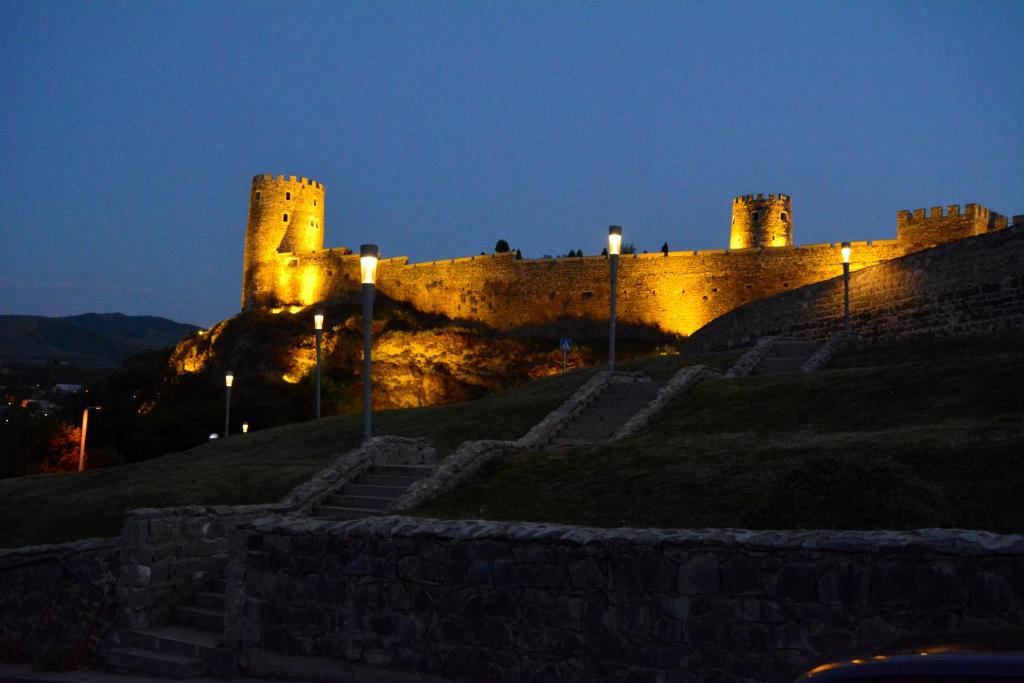 un castillo sentado en la cima de una colina por la noche en ART-Rabat, en Akhaltsikhe
