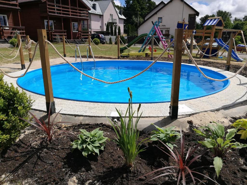 a pool with a swing in a yard at Osada Rybacka in Jastrzębia Góra