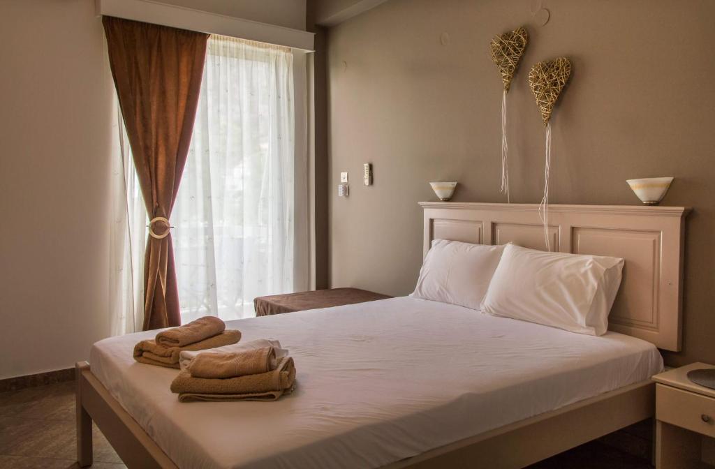 a bedroom with a bed with two towels on it at Maltezos Rooms in Methana