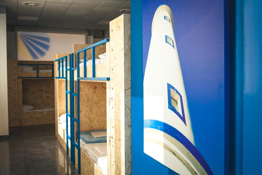 two bunk beds in a room with a surfboard at Estela do Mar in Baiona