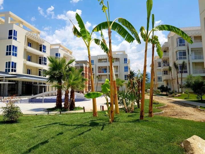 a group of palm trees in front of a building at Radhima Beach Apartment-Tirana Resort in Orikum