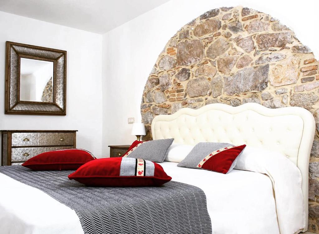 a bedroom with a large white bed with red pillows at Ogliastra Luxury Apartment in Tortolì