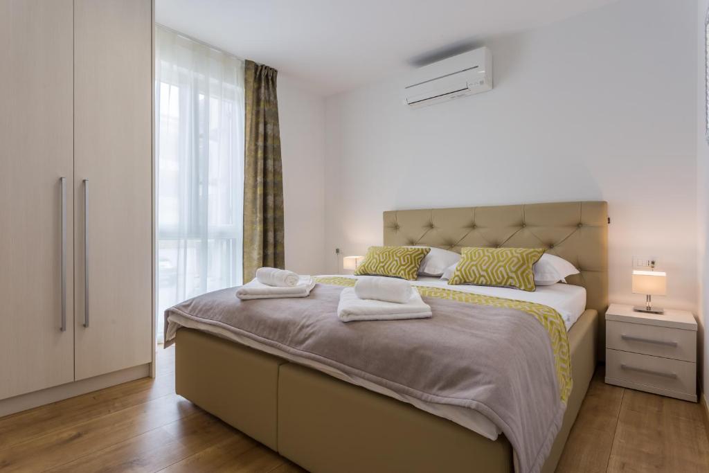 sypialnia z dużym łóżkiem z ręcznikami w obiekcie Pure Relax w mieście Malinska