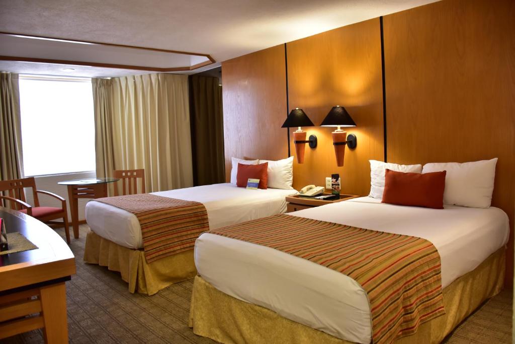 Postel nebo postele na pokoji v ubytování Hotel Guadalajara Plaza Ejecutivo