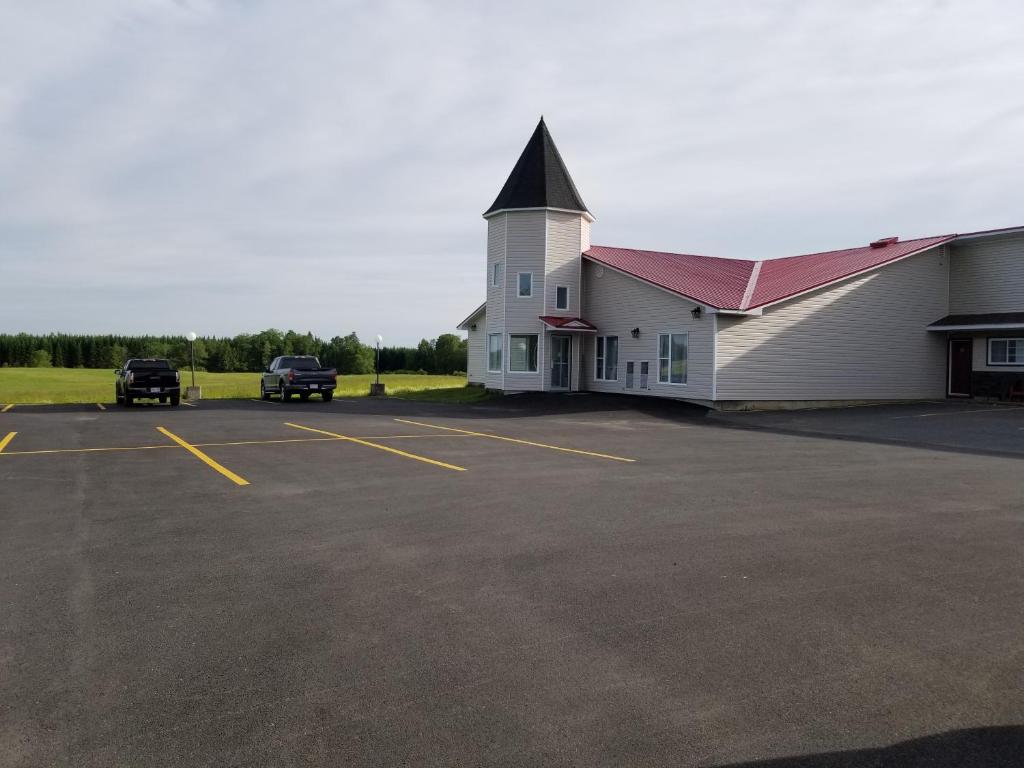 una iglesia con coches estacionados en un estacionamiento en Knights Inn Woodstock en Woodstock