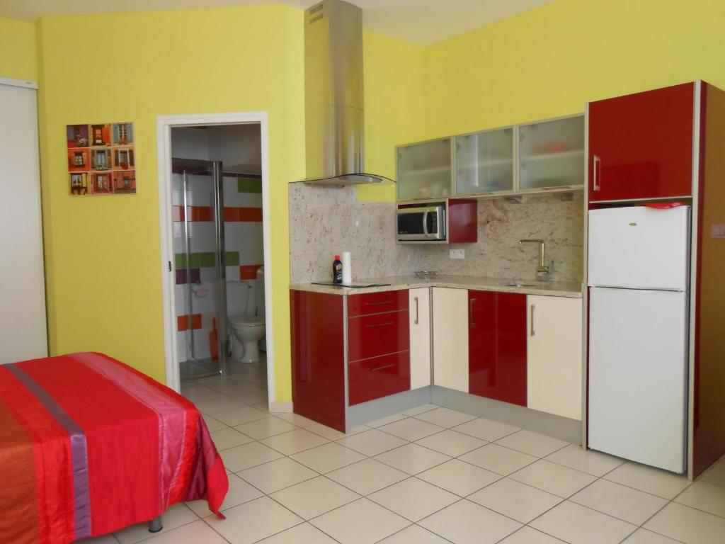 アメリー・レ・バン・パラルダにあるLes Mimosasの赤と白のキャビネットと黄色の壁が備わるキッチン
