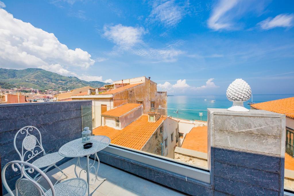 uma varanda com uma mesa e vista para o oceano em Ossuna Bay Hotel Boutique em Cefalù