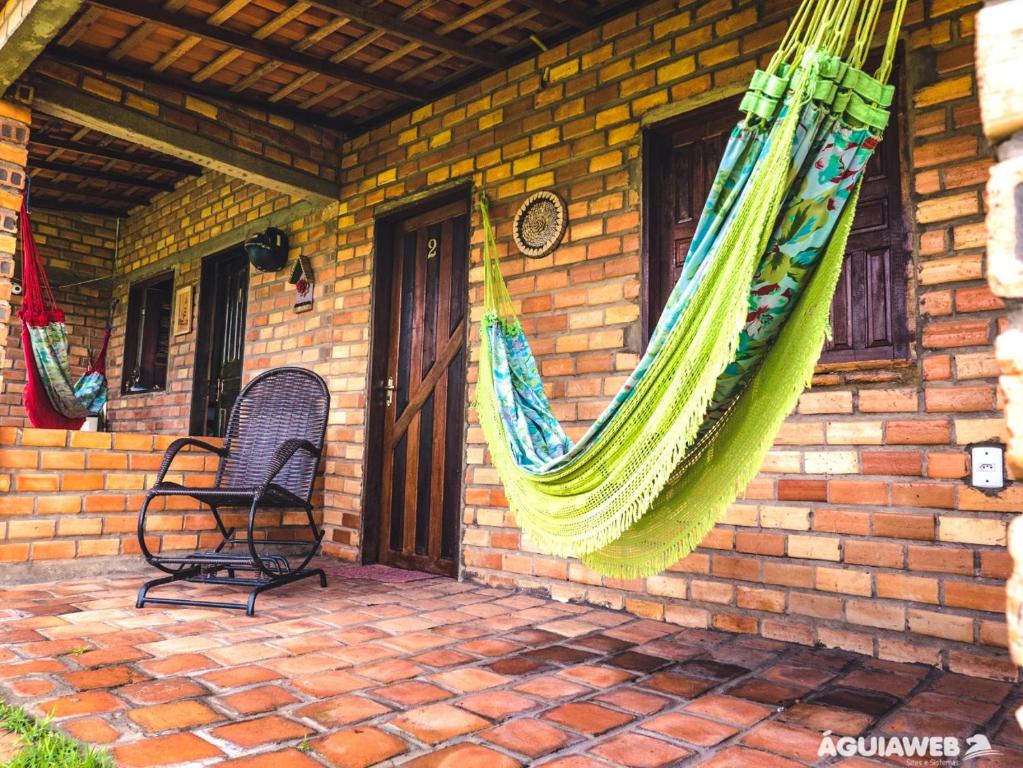 eine Terrasse mit einer Hängematte, die von einem Backsteinhaus hängt in der Unterkunft Pousada Da Bell in Barreirinhas