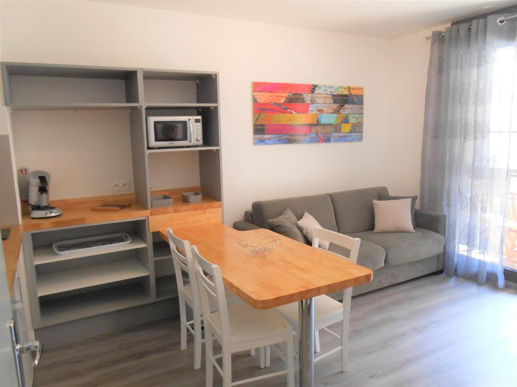 uma sala de estar com uma mesa e um sofá em Appartement 4p luchon cures & ski Soda em Luchon