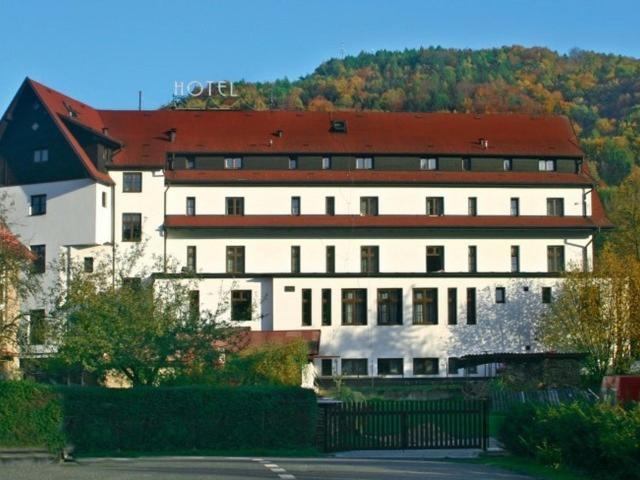 ein großes weißes Gebäude mit rotem Dach in der Unterkunft Hotel Skála in Malá Skála