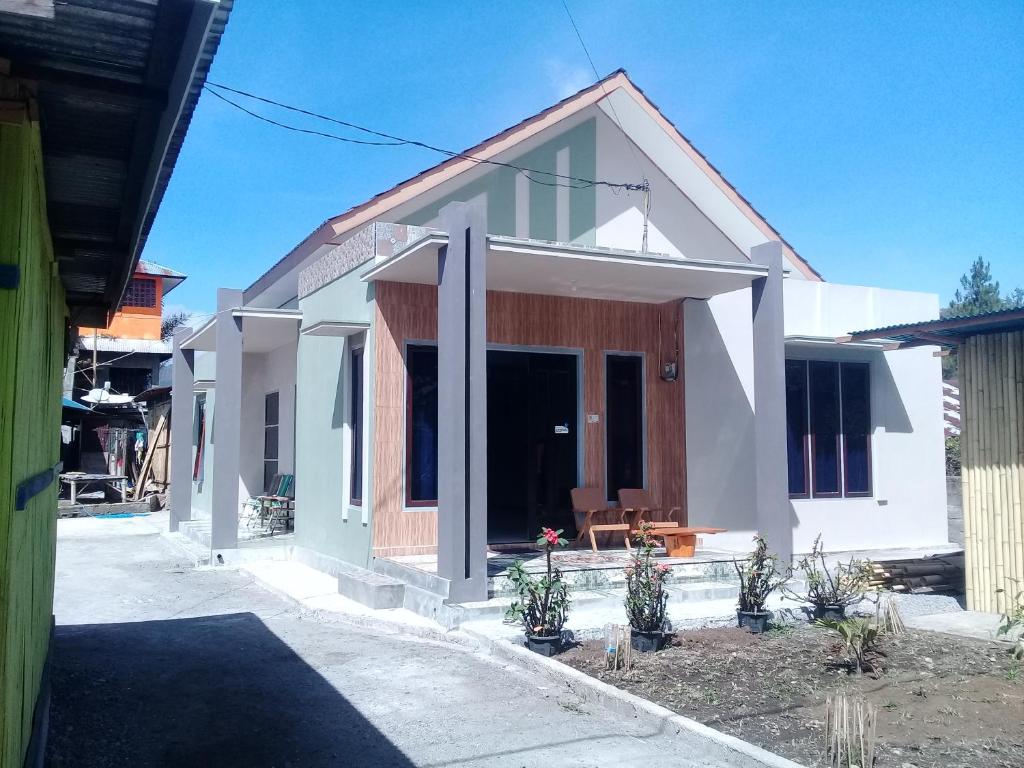 Casa pequeña con paredes y ventanas blancas en Cinnamon Guest House, en Bajawa