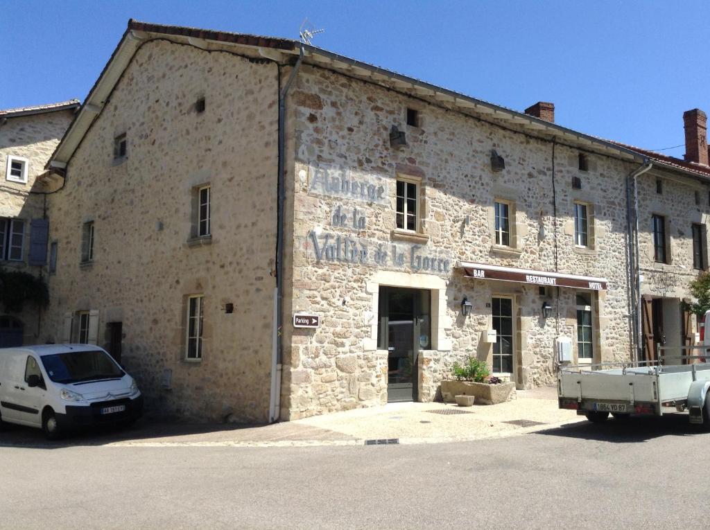 un edificio de piedra con un coche aparcado delante de él en Auberge de la vallee de la gorre, en Saint-Auvent