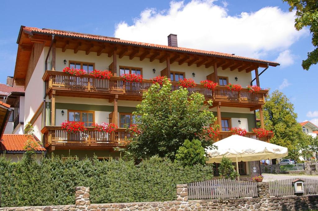 a building with red flowers on the balconies at Pension Zur Alten Schmiede in Zwiesel