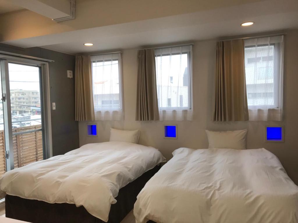 Кровать или кровати в номере Across Omoromachi Naha