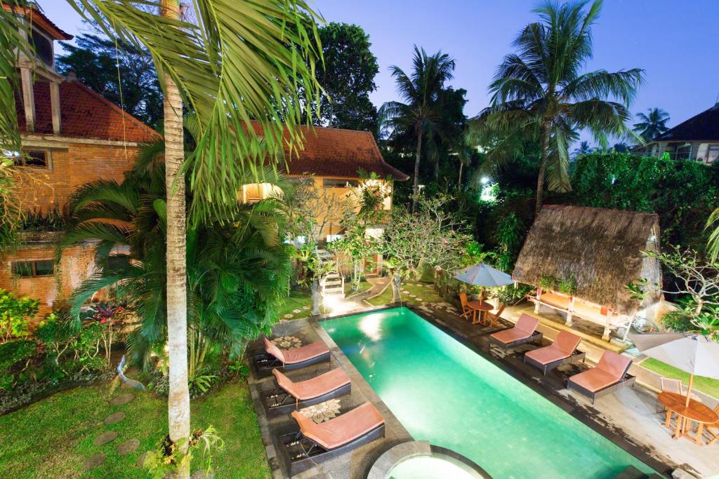 an overhead view of a swimming pool with lounge chairs at Wenara Bali Bungalows in Ubud