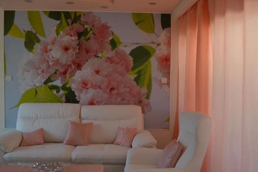 een woonkamer met een witte bank en roze bloemen bij Двуспальная квартира возле дасуди in Limassol