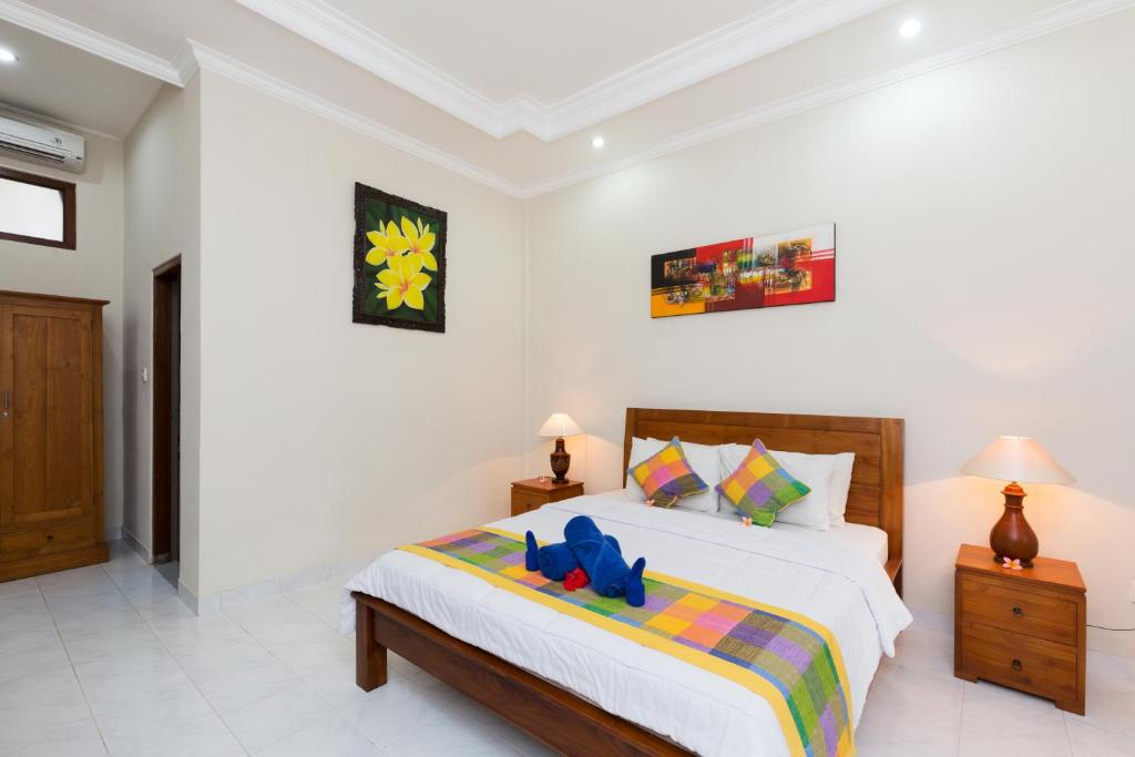 a bedroom with a bed with a stuffed animal on it at Wenara Bali Bungalows in Ubud