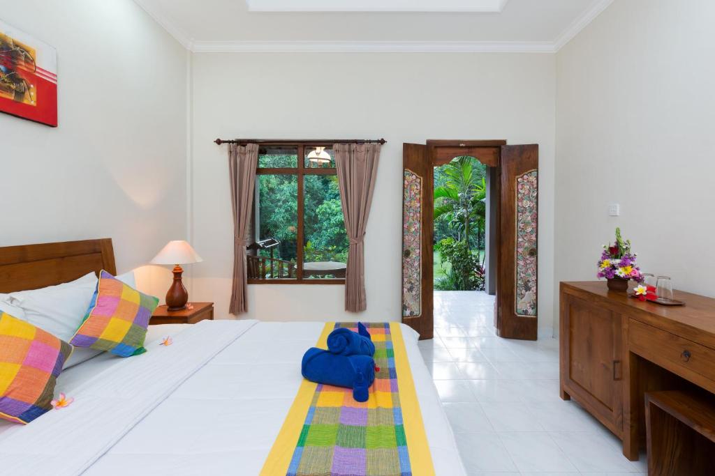 a bedroom with a bed with a blue elephant on it at Wenara Bali Bungalows in Ubud