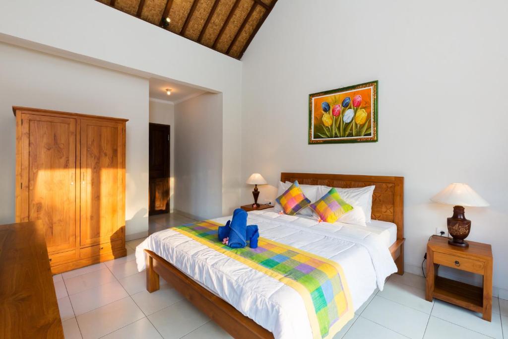 a bedroom with a bed with a blue box on it at Wenara Bali Bungalows in Ubud