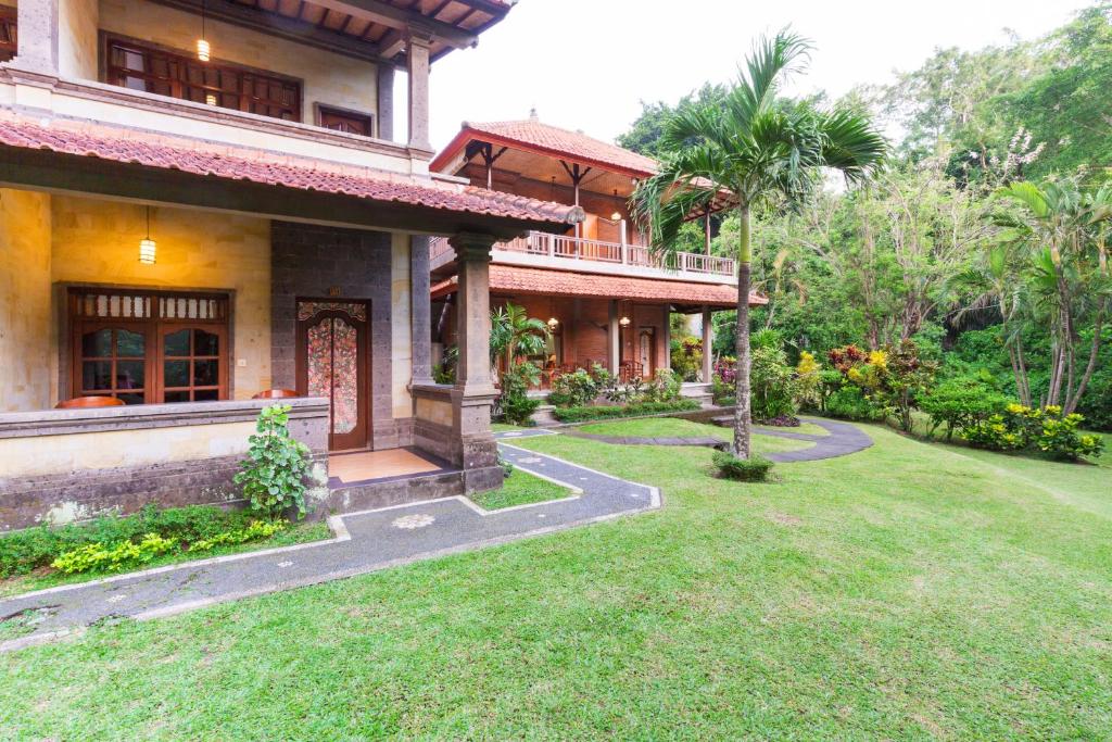 a house with a lawn in front of it at Wenara Bali Bungalows in Ubud