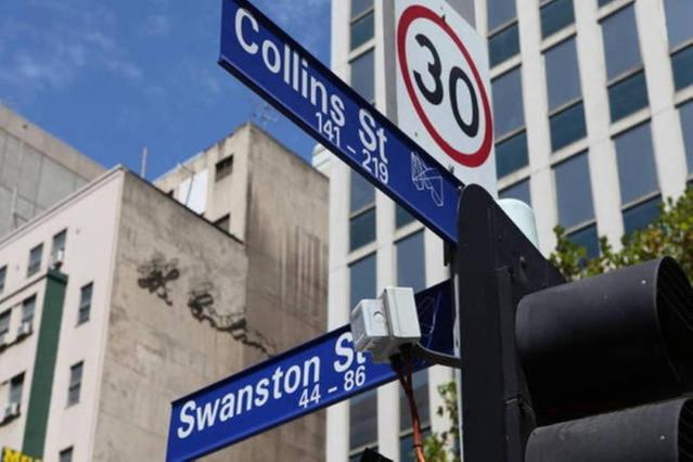 two blue street signs on a traffic light with a building at Pleasant City Stay on Collins in Melbourne