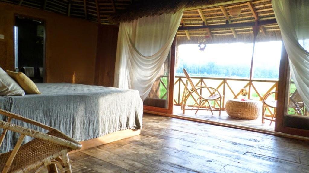 a bedroom with a bed and a large window at Huma Terra Lodges in Hikkaduwa