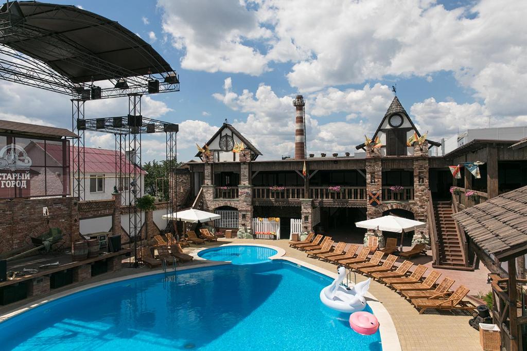 ein großer Pool mit Stühlen und ein Gebäude in der Unterkunft Old Town Hotel in Rostow am Don