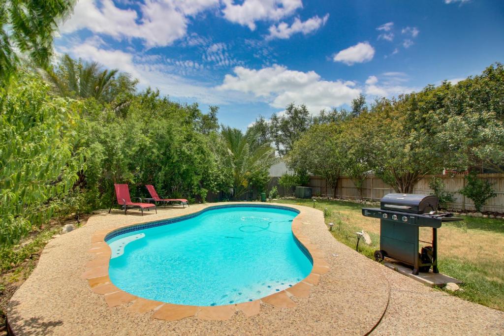 a swimming pool in a yard with a grill at Peaceful at Vinca Pass in San Antonio