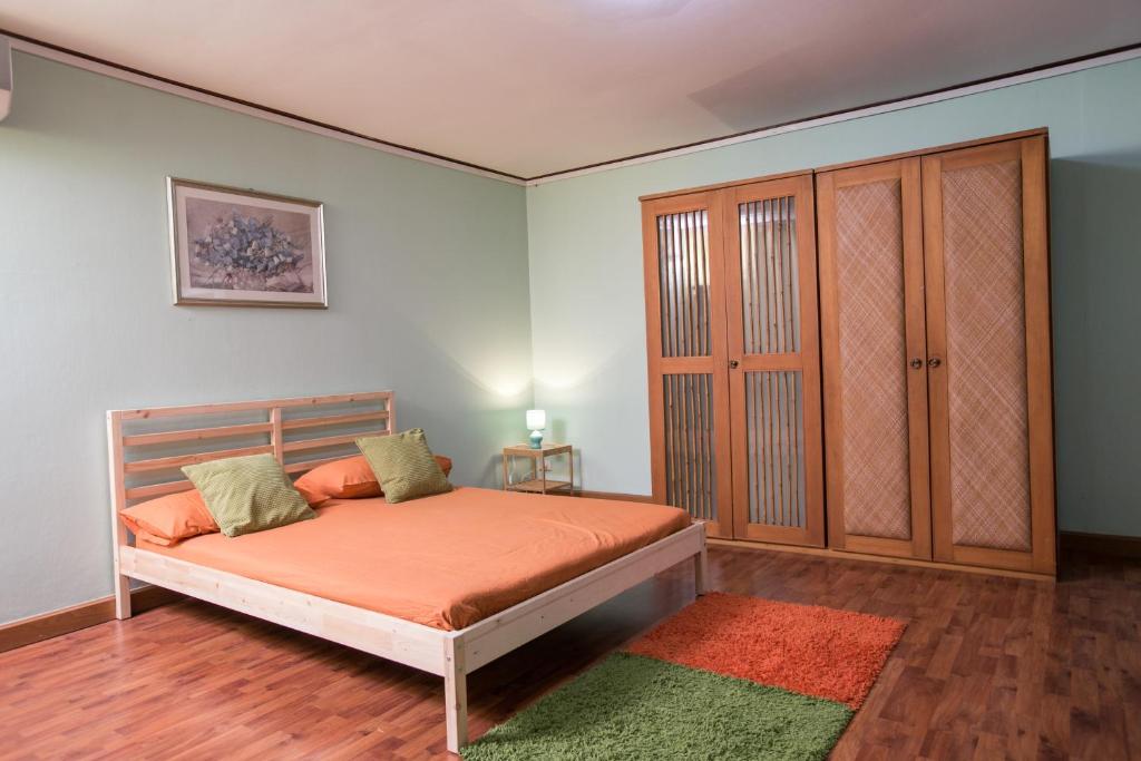 a bedroom with a bed with orange sheets and a green rug at The Chan - Sri Ayutthaya Road in Bangkok