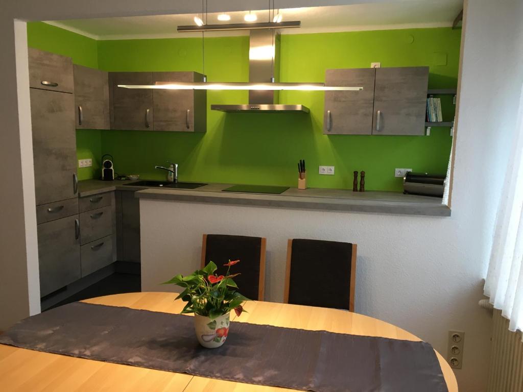 a kitchen with a table and a green wall at Karls Ferienwohnung in Teufenbach