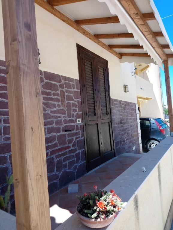 a porch of a house with a door and a flower pot at Apartment of kite and wine in Birgi Vecchi