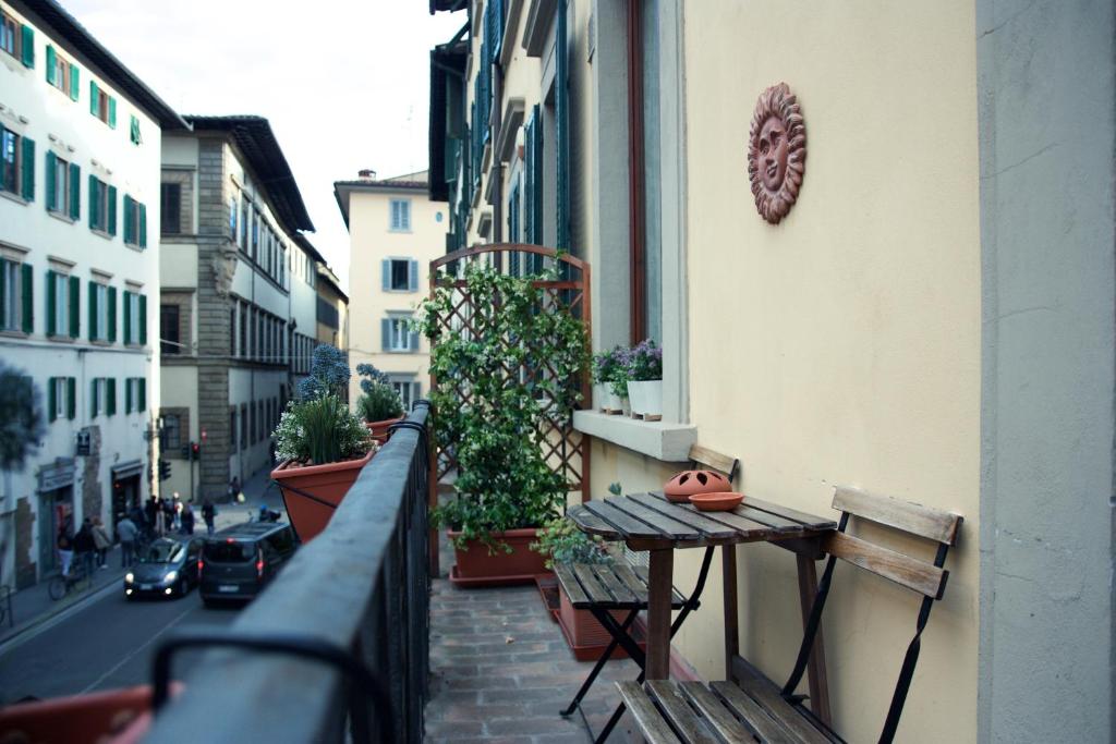 uma varanda com uma mesa e bancos numa rua em Luxury central flat river view em Florença