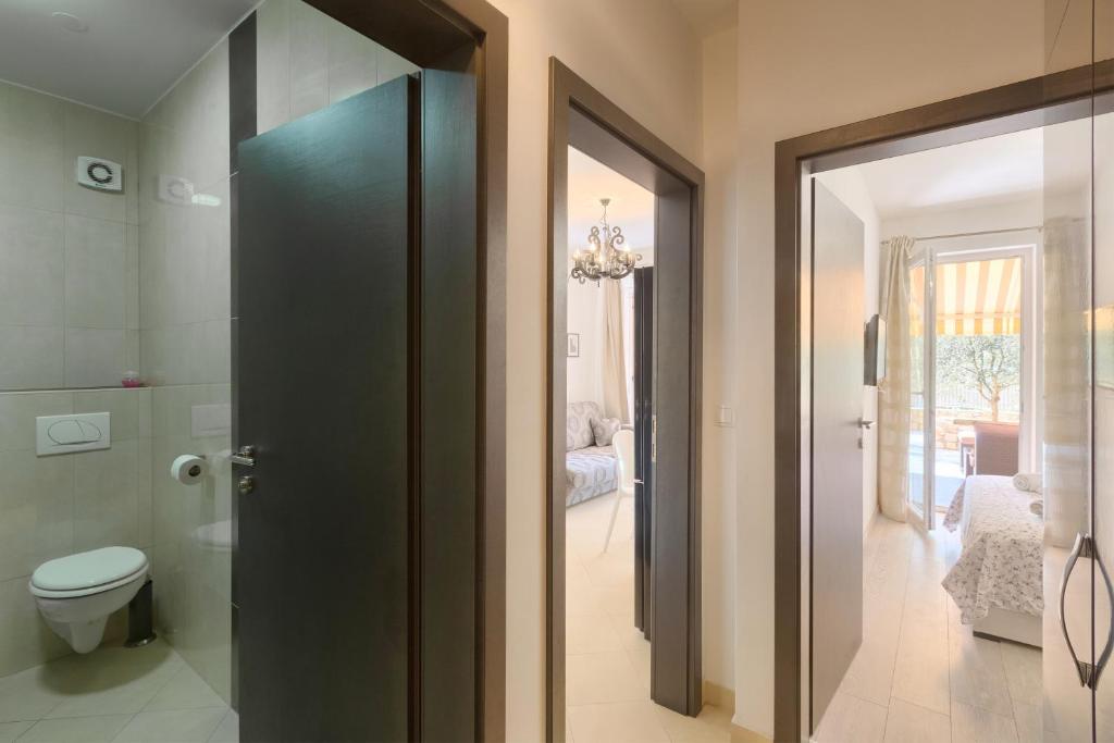 łazienka z toaletą i szklanymi drzwiami w obiekcie Apartment Robert w Novalji