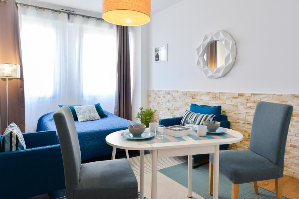 トゥールーズにあるBleue Loft Ramblas Centre Toulouseのリビングルーム(青いソファ、テーブル、椅子付)