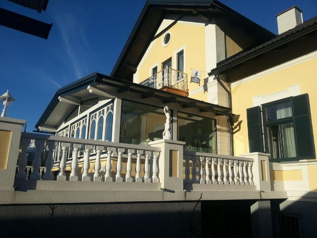 einen weißen Balkon auf einem Haus mit einem Zaun in der Unterkunft Villa Elisabeth in Admont