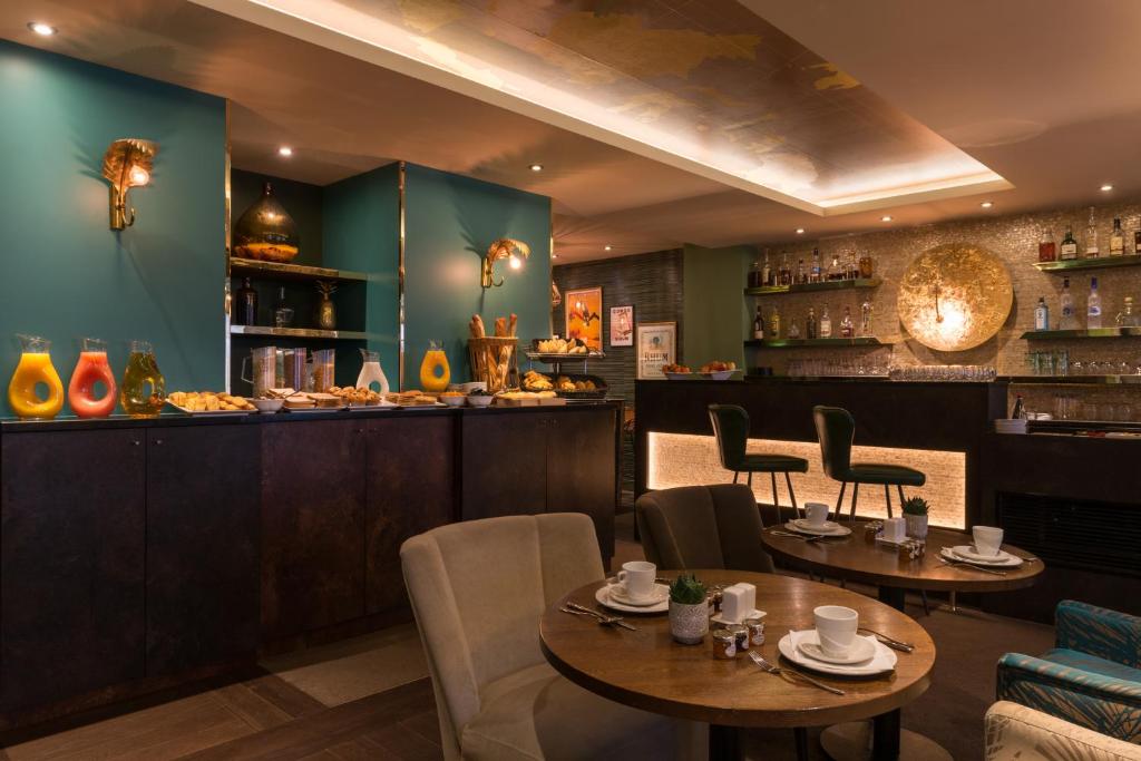 a restaurant with two tables and chairs and a bar at Hôtel La Bourdonnais by Inwood Hotels in Paris