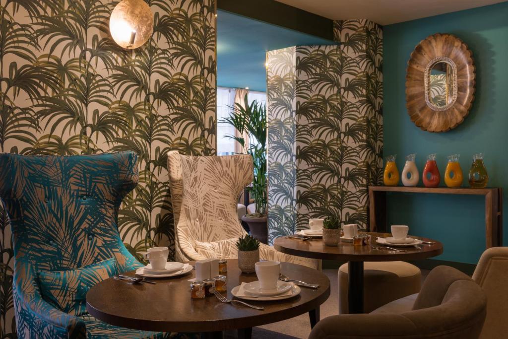 a dining room with two tables and a chair at Hôtel La Bourdonnais by Inwood Hotels in Paris