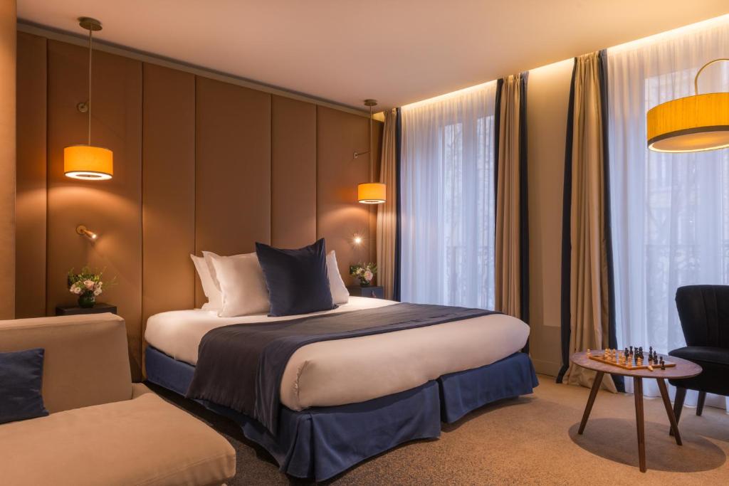a hotel room with a bed and a chair at Hôtel La Bourdonnais by Inwood Hotels in Paris