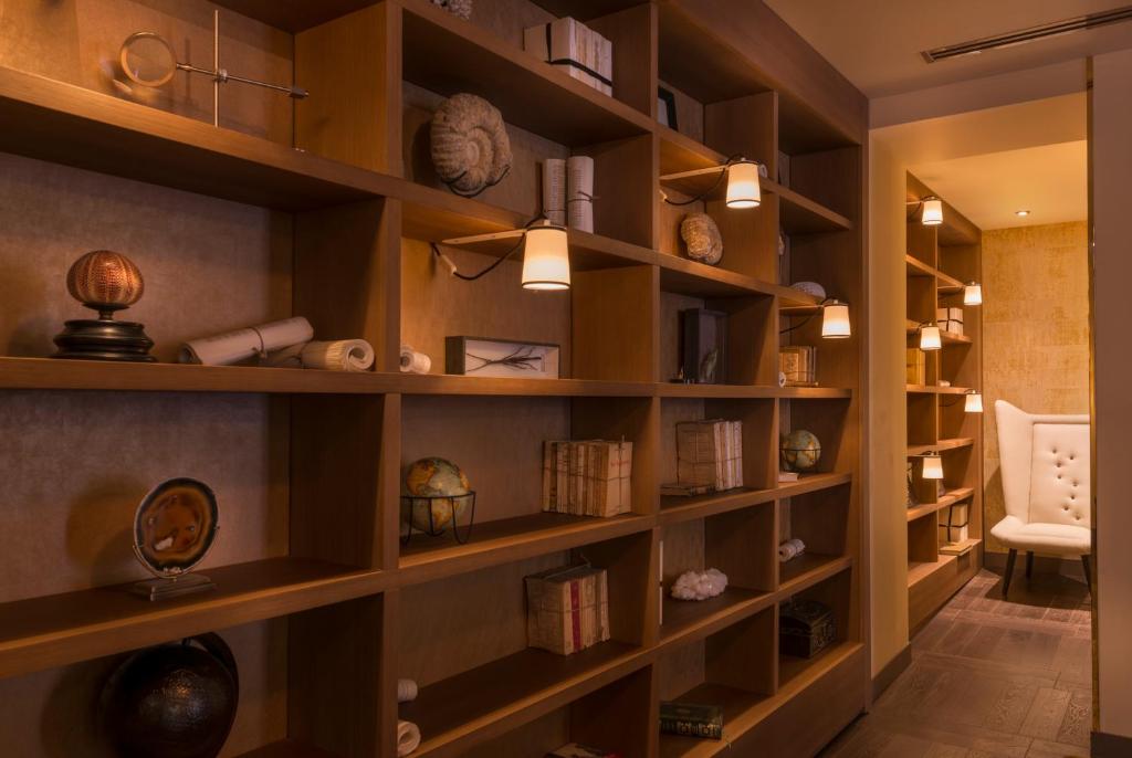 a library with wooden shelves filled with books at Hôtel La Bourdonnais by Inwood Hotels in Paris