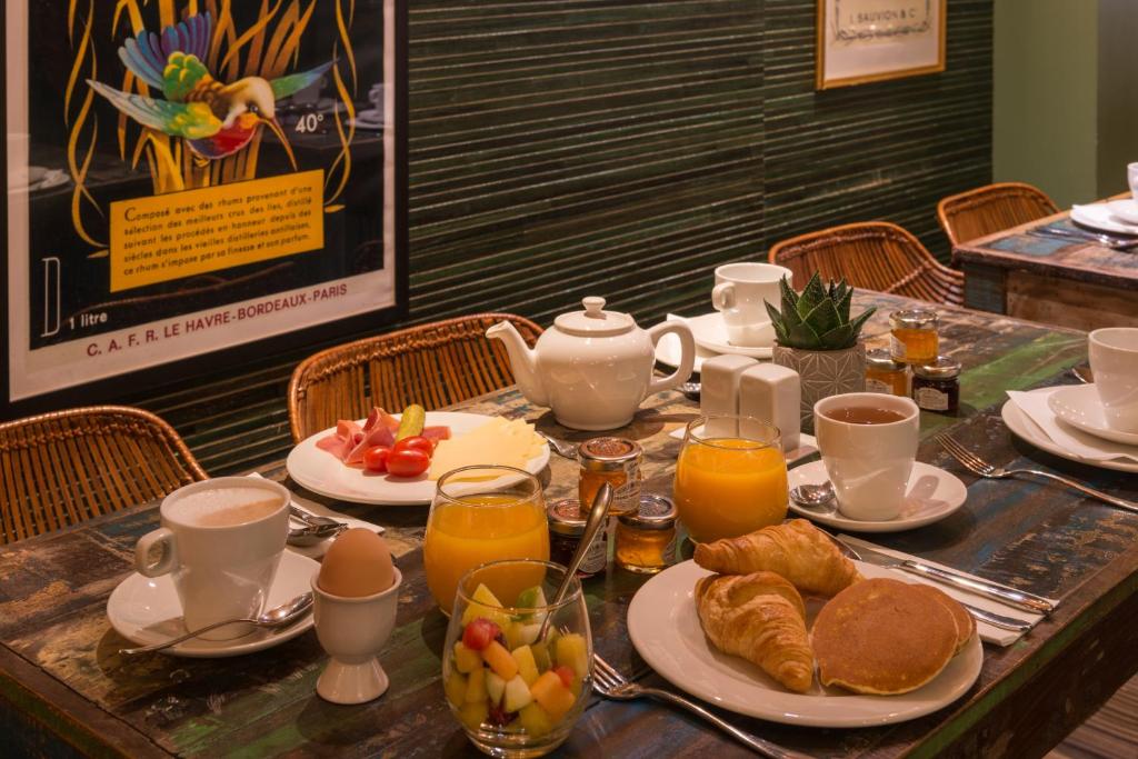 a table with a breakfast of croissants and orange juice at Hôtel La Bourdonnais by Inwood Hotels in Paris