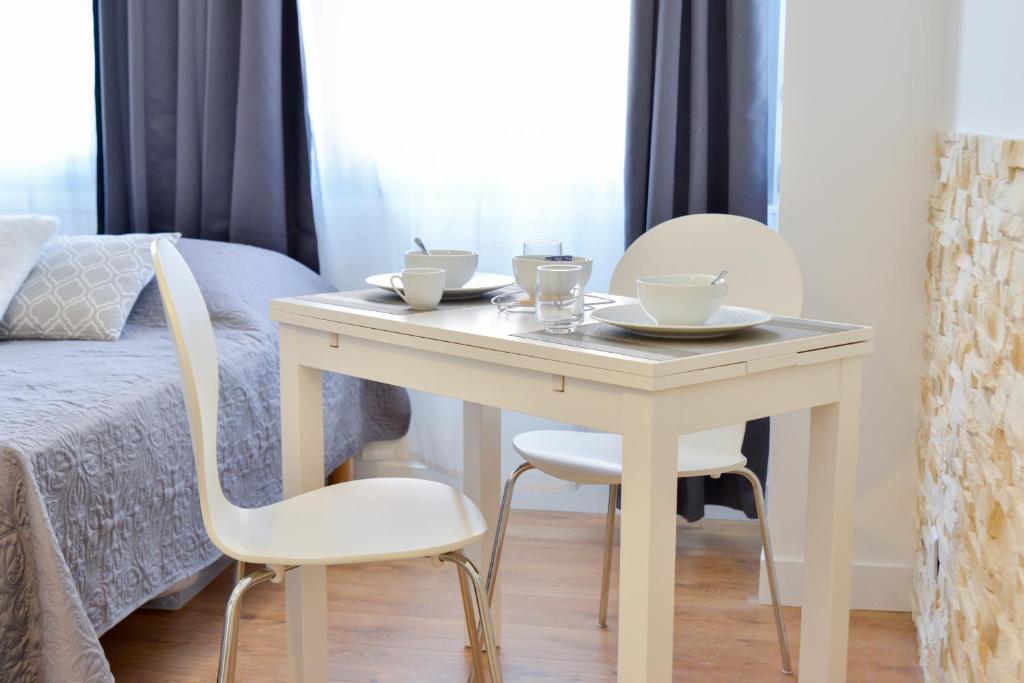トゥールーズにあるNice Flat Ramblas Centre Toulouseの白いテーブル(椅子2脚付)とベッド1台