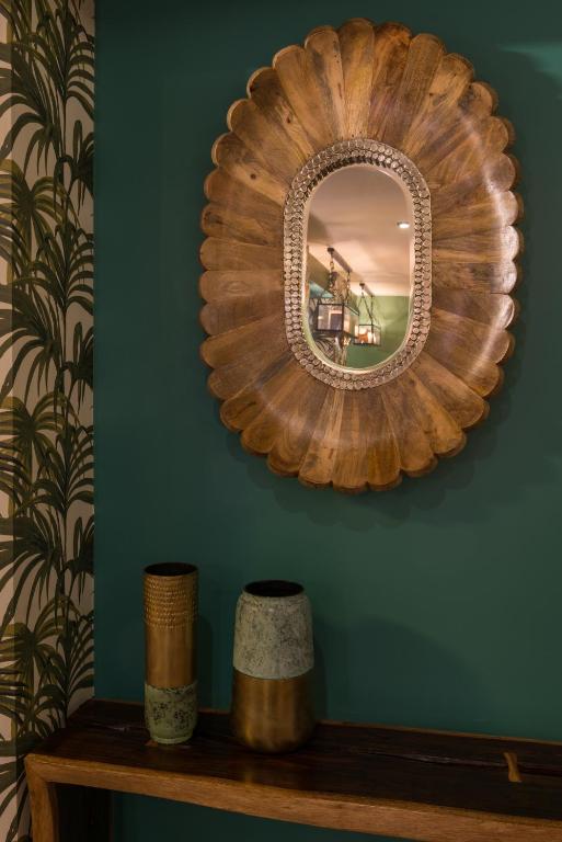 a wooden mirror on a green wall with a shelf at Hôtel La Bourdonnais by Inwood Hotels in Paris