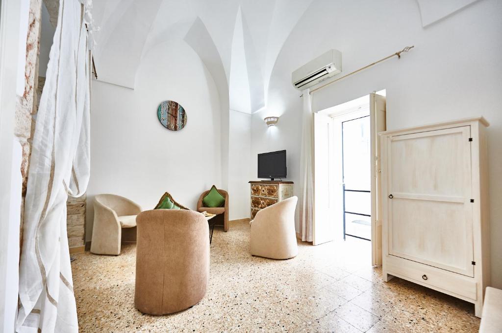 a living room with two chairs and a door at EQUORUM 13 - Ostuni Centro in Ostuni