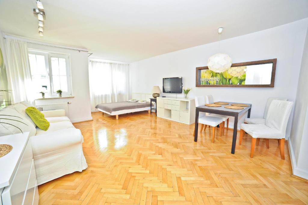 a living room with a white couch and a table at Grand Apartments Tulipan in Sopot