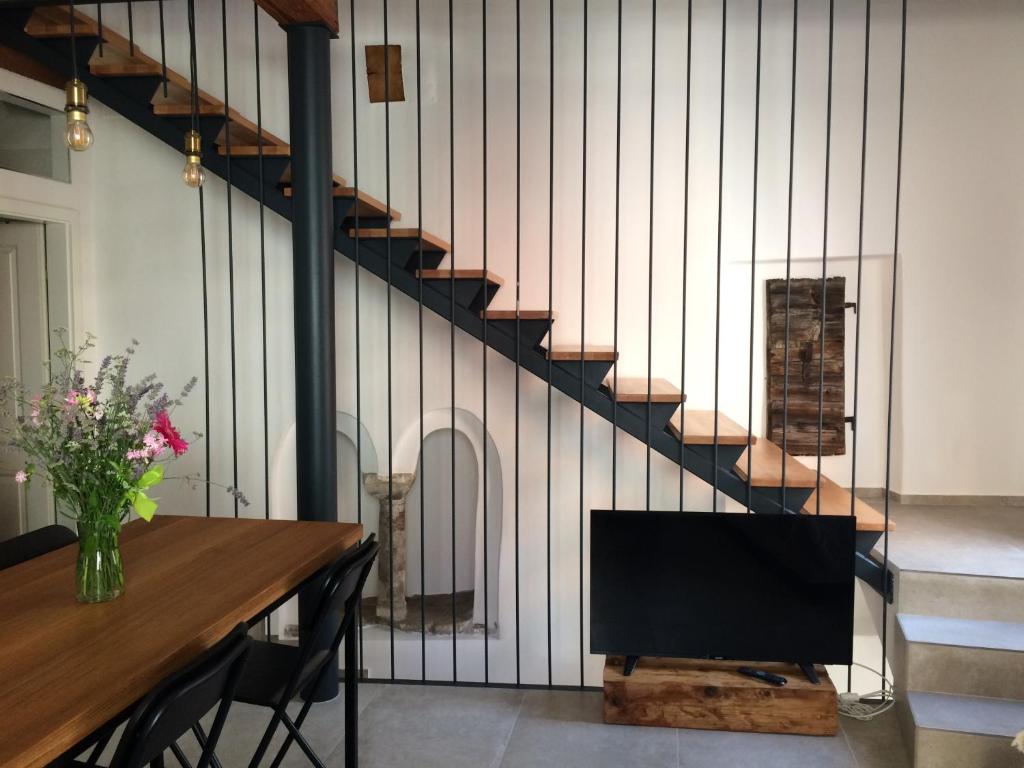 een woonkamer met een tafel en een tv en een trap bij Casa Bibiana in Koper